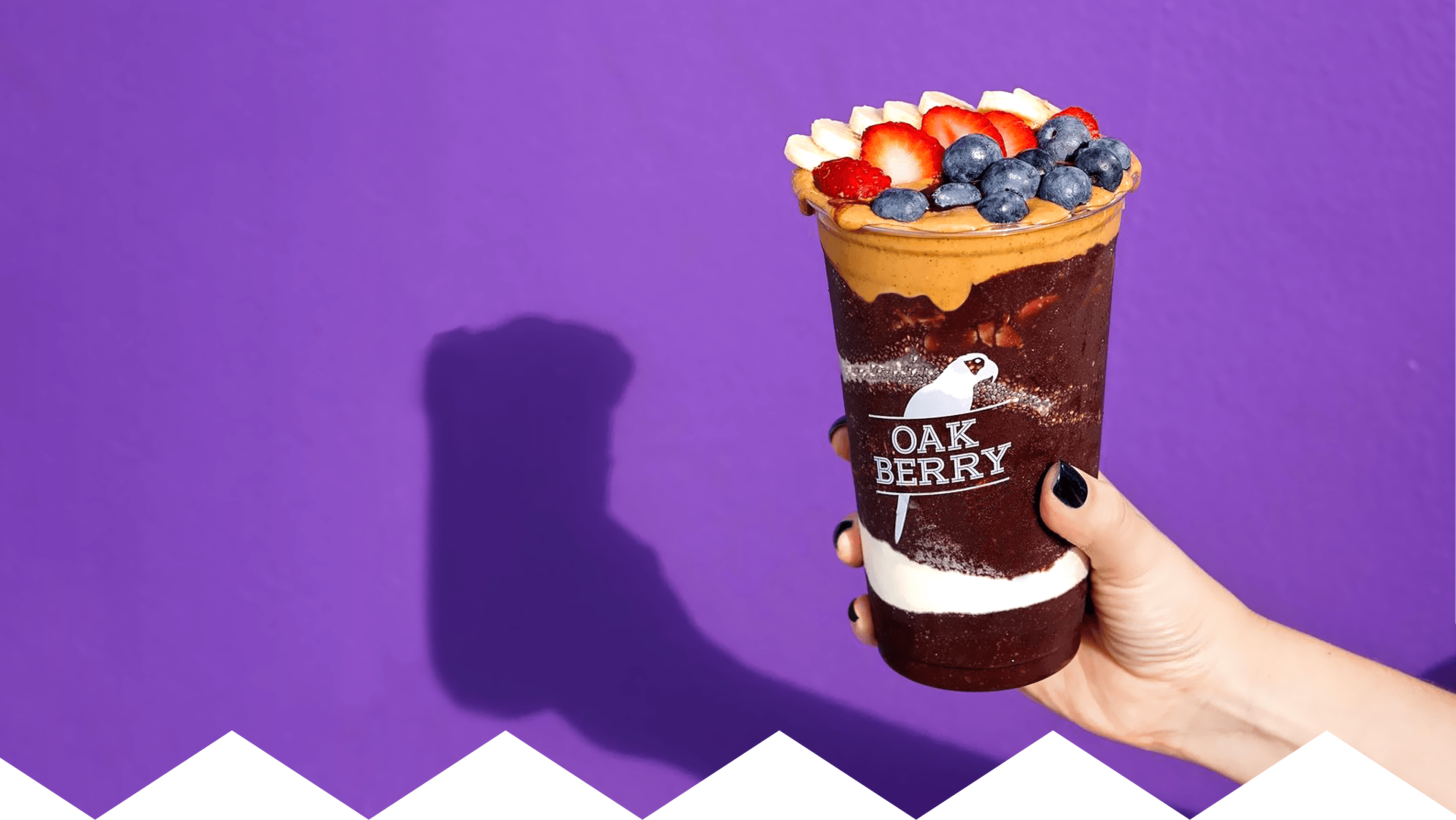 A hand holding a OAKBERRY bowl